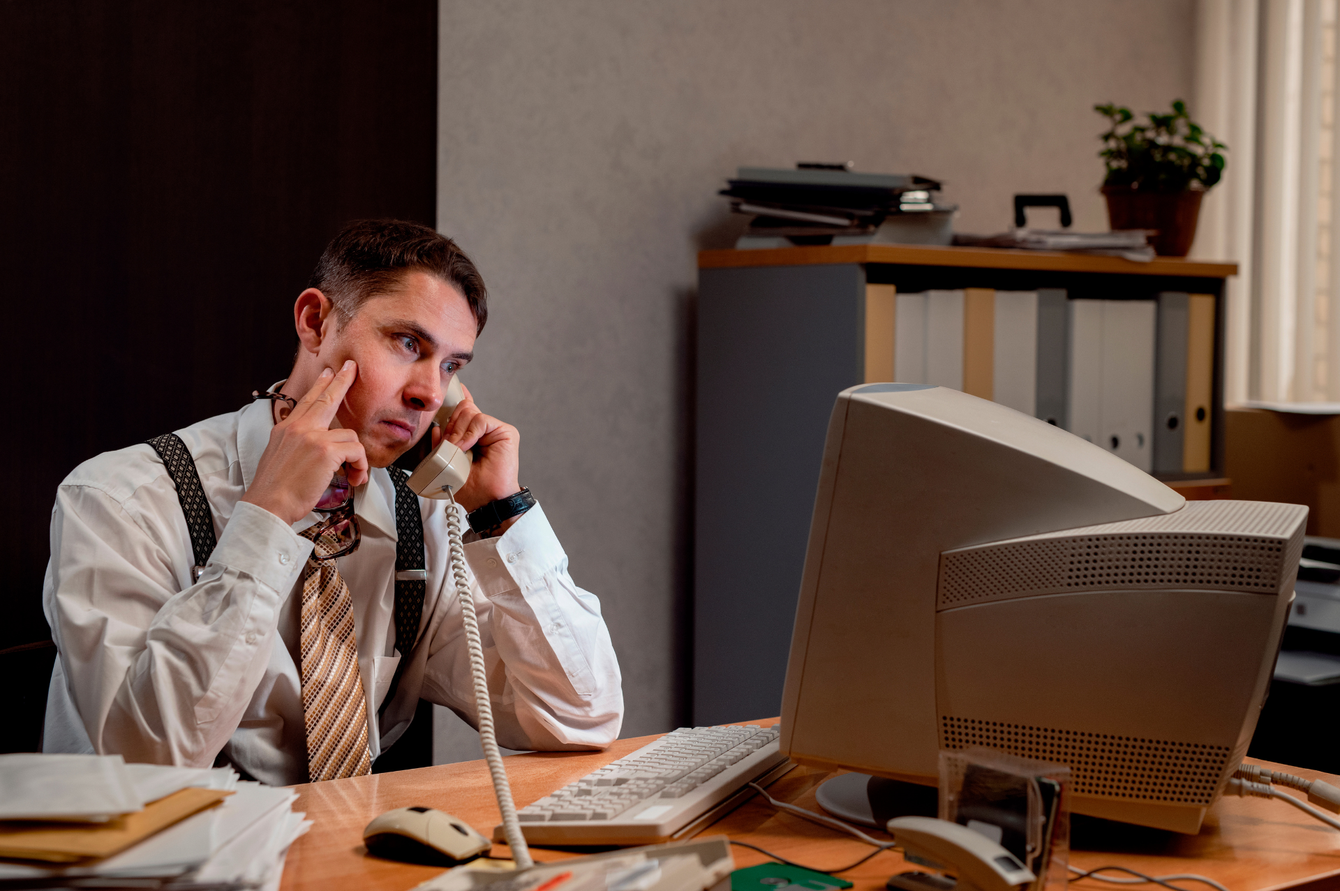 This is an image of a frustrated businessman on an old telephone.