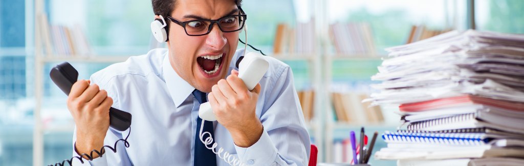 Frustrated businessman shouting at two old phones