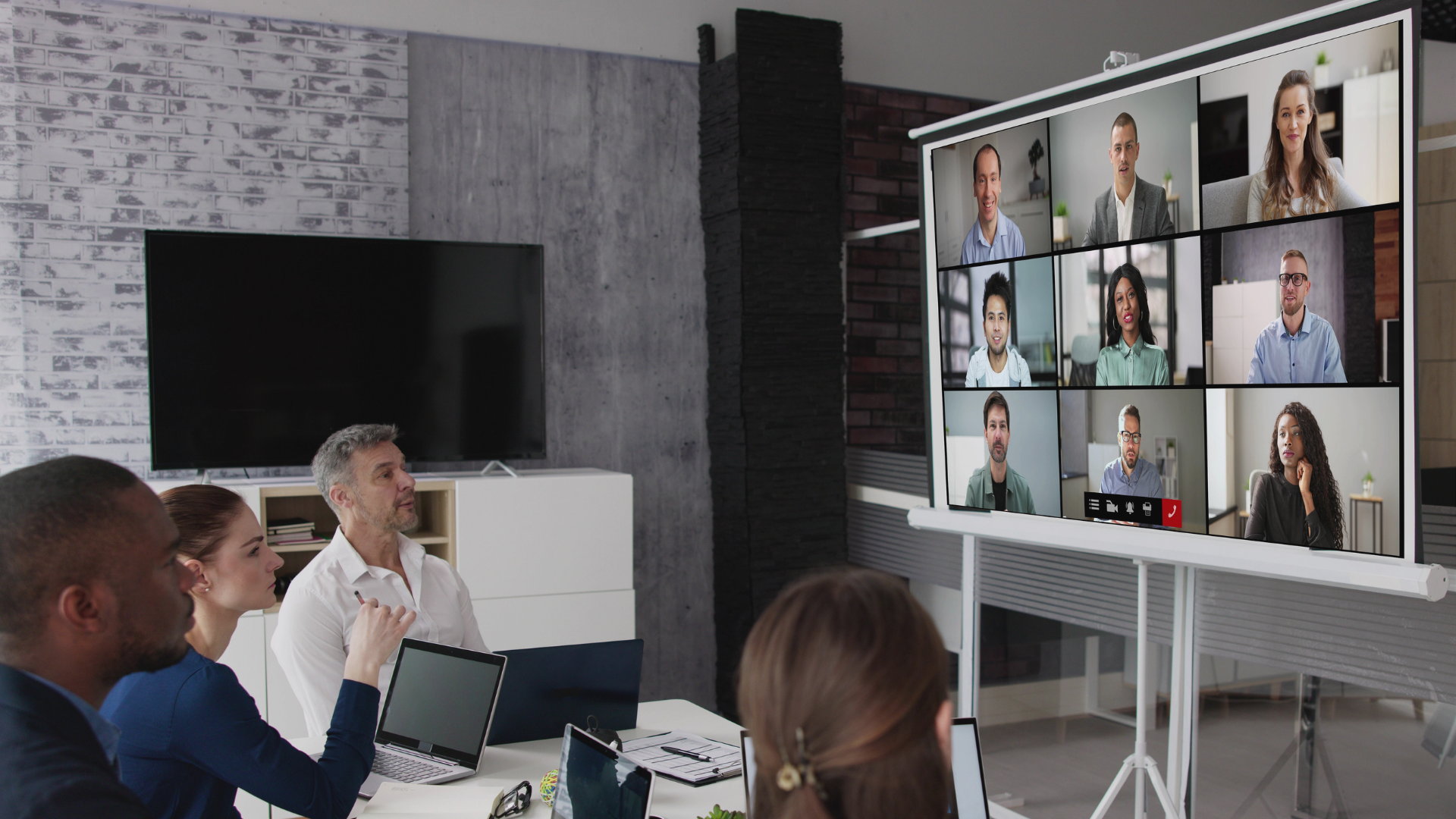 This is an image of people in a boardroom on a conference call.
