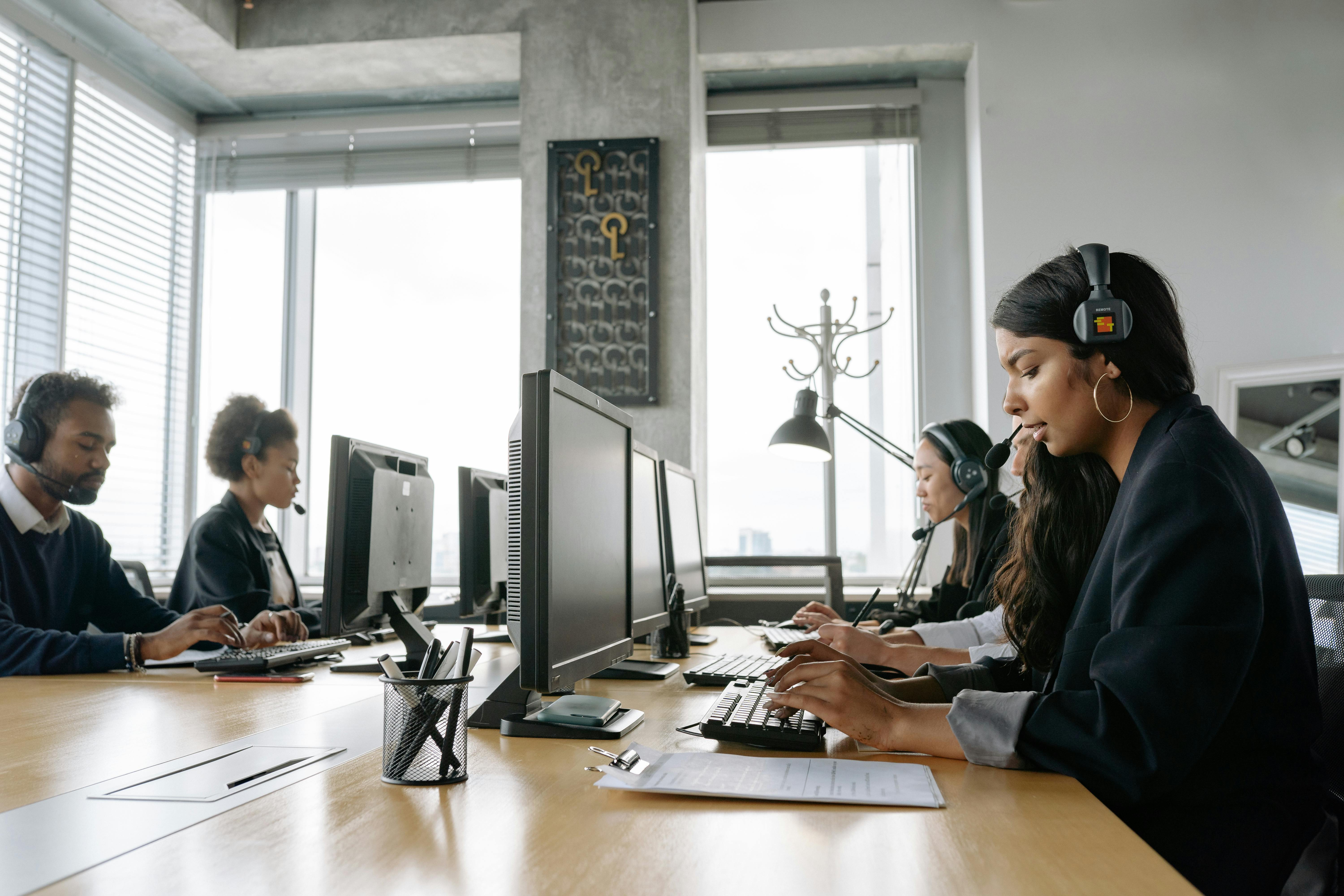 This is an image of people working in an office with headsets on.